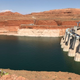 Glen Canyon Dam holds water in Lake Powell against a backdrop of red, desert rock.